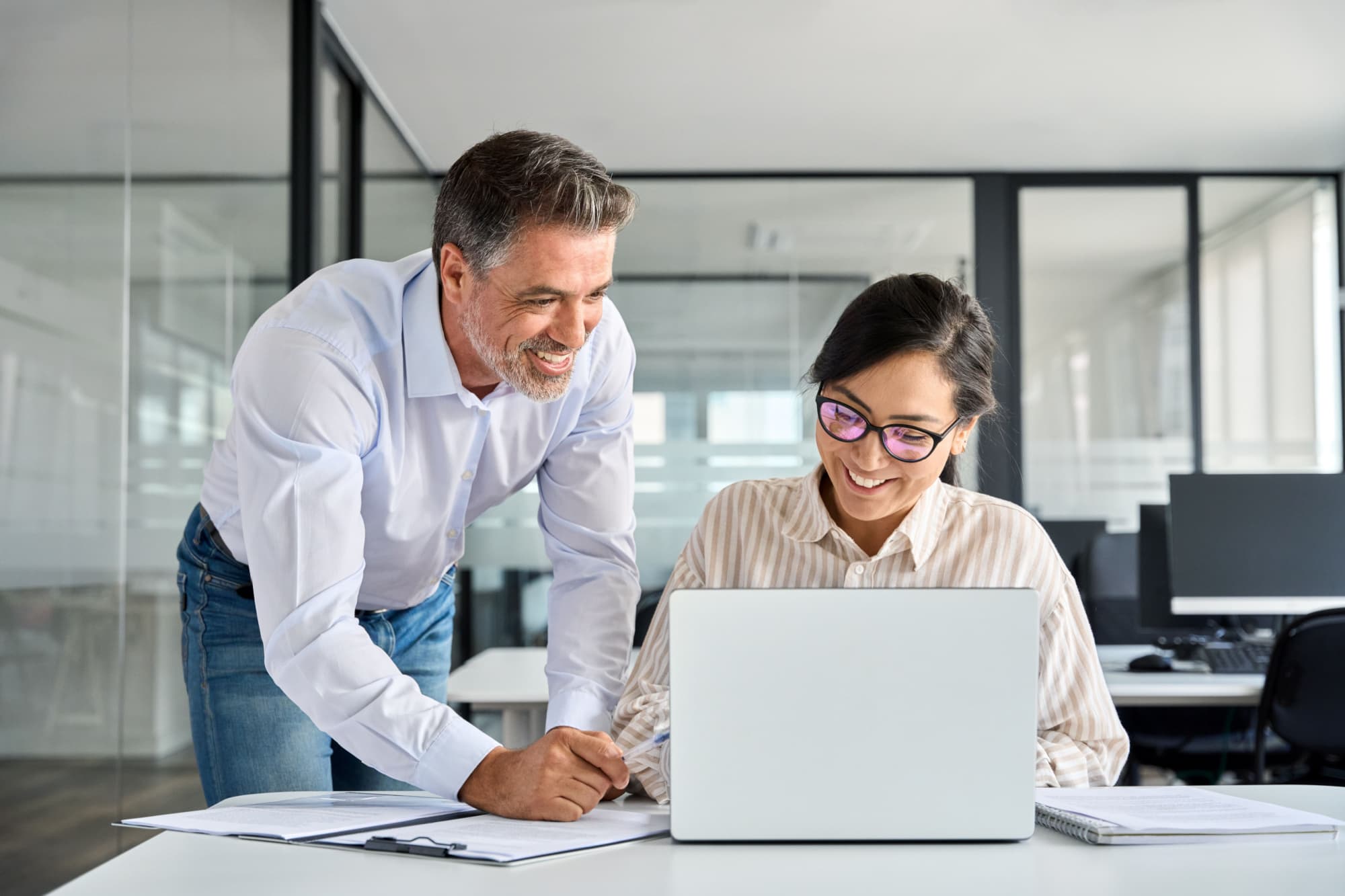 Two happy professional coworkers discussing online plan at work.