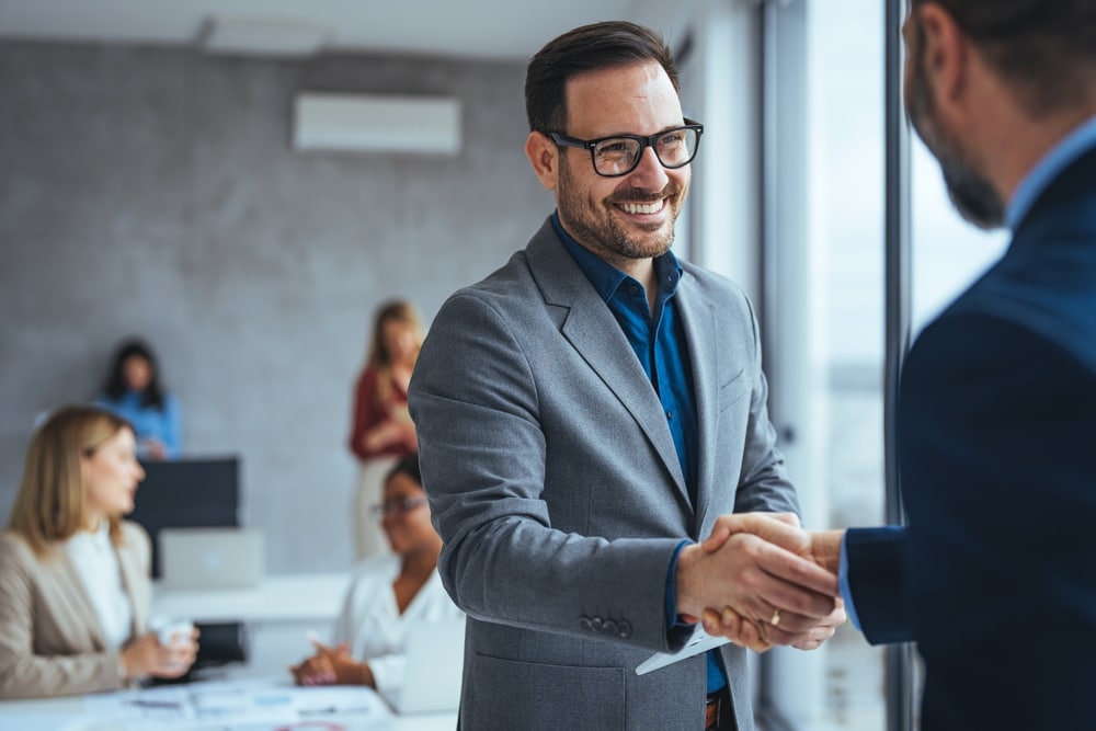Shot of two businessmen shaking hands in an office.
